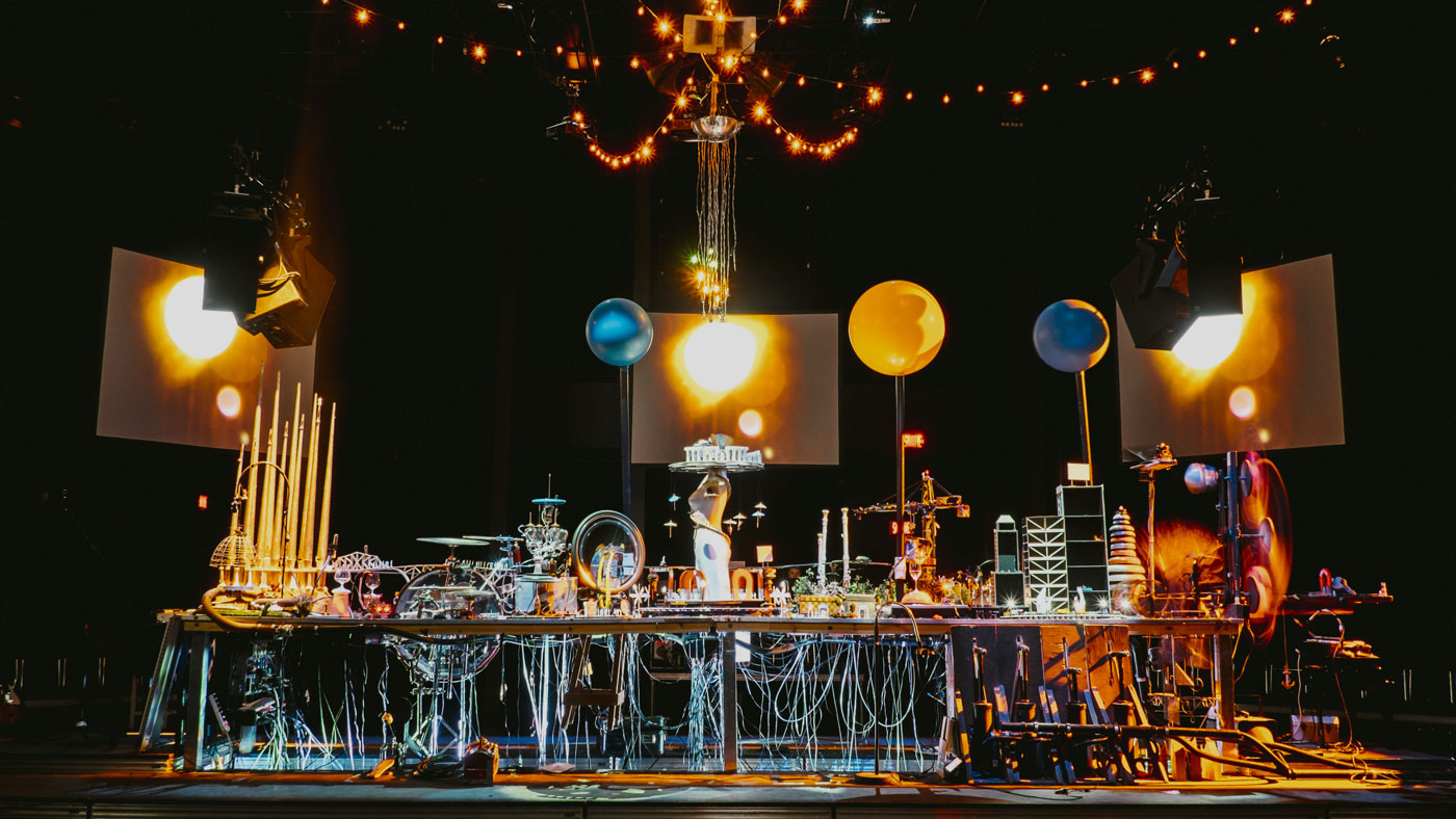 Scène de spectacle avec une installation artistique mécanique complexe, des lumières de scène et des décorations suspendues