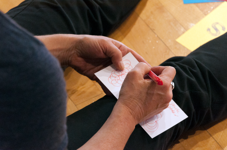 Gros plan sur des mains qui griffonnent un dessin.