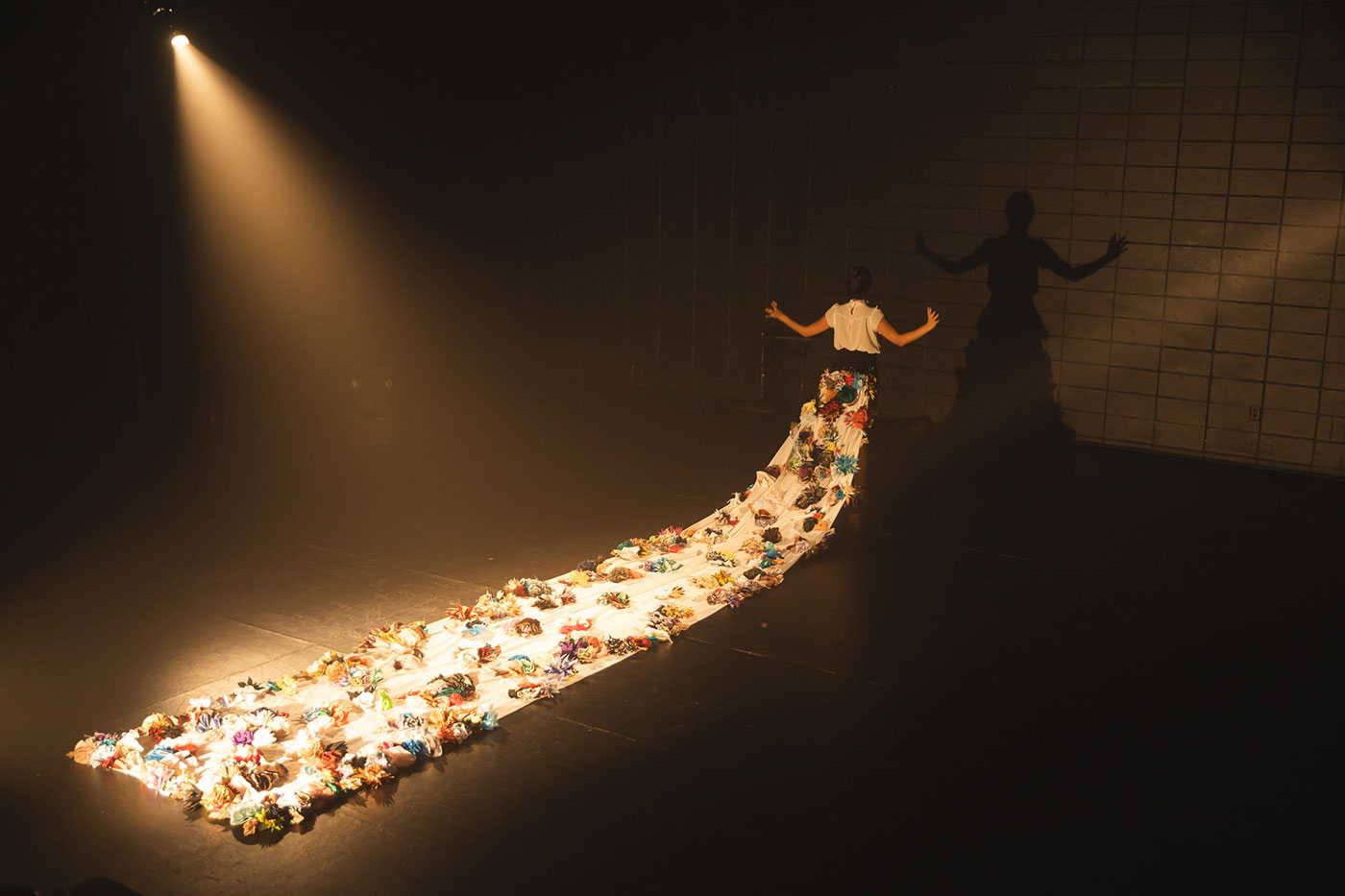 Une personne avec une robe ayant une grande traine de fleurs