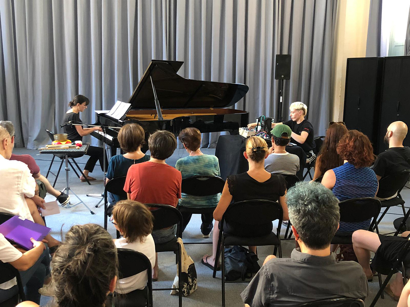 Femme jouant du piano devant une foule